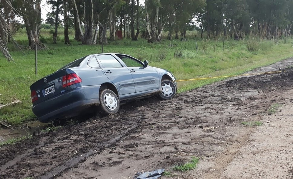 Voiture enlisée dans un chemin boueux, sangle de remorquage attachée
